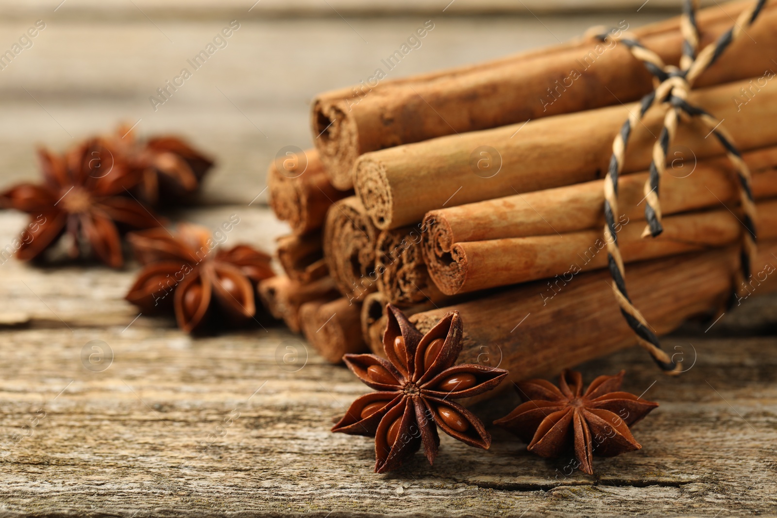 Photo of Cinnamon sticks and star anise on wooden table, closeup