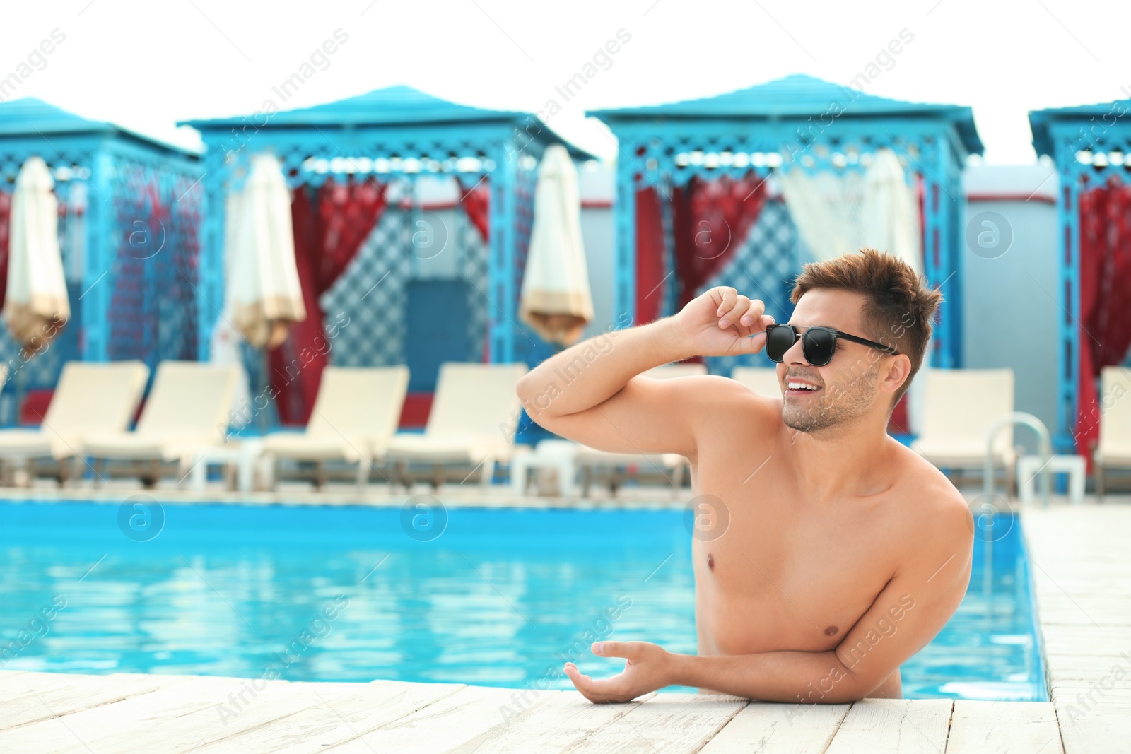 Photo of Handsome young man in swimming pool on sunny day