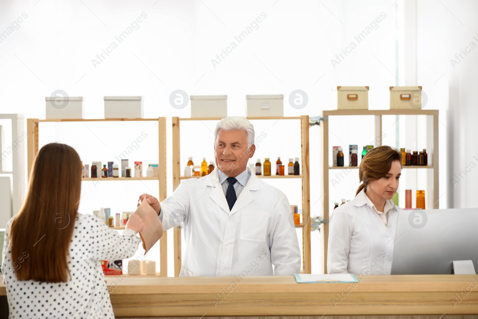 Photo of Pharmacist giving medicine to customer in drugstore