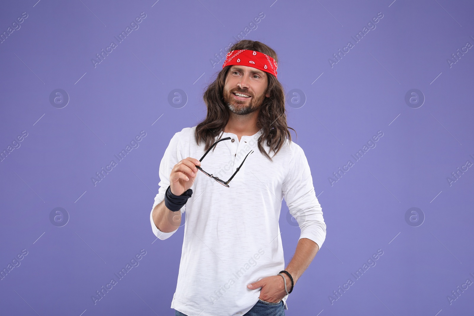 Photo of Stylish hippie man with sunglasses on violet background