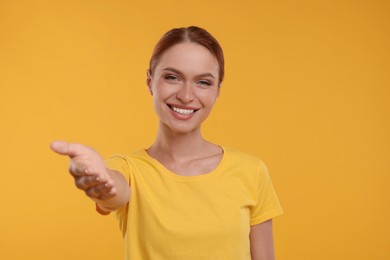 Photo of Beautiful happy woman welcoming on yellow background