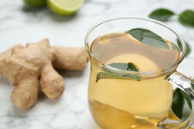 Photo of Diet herbal tea with green leaves on table, closeup