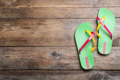 Photo of Stylish flip flops on wooden background, flat lay. Space for text