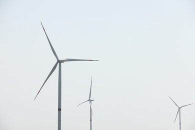 Modern wind turbines against blue sky. Energy efficiency