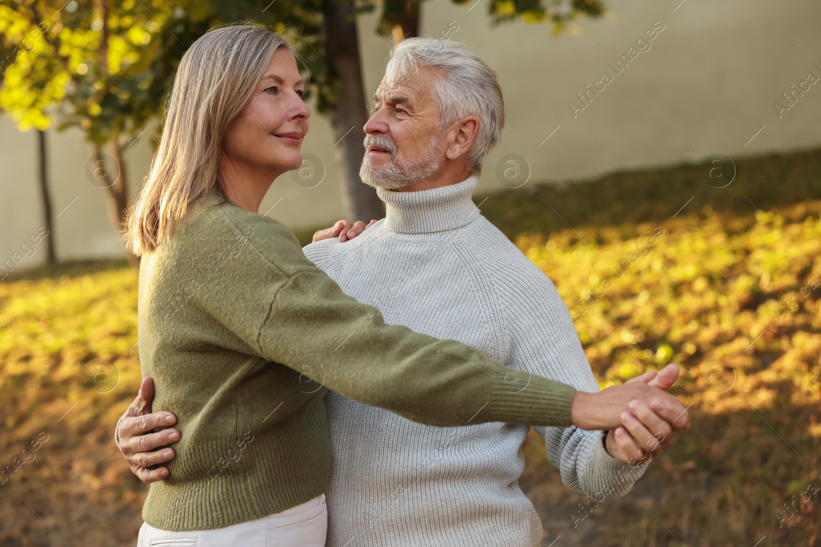 Photo of Affectionate senior couple dancing together outdoors. Romantic date