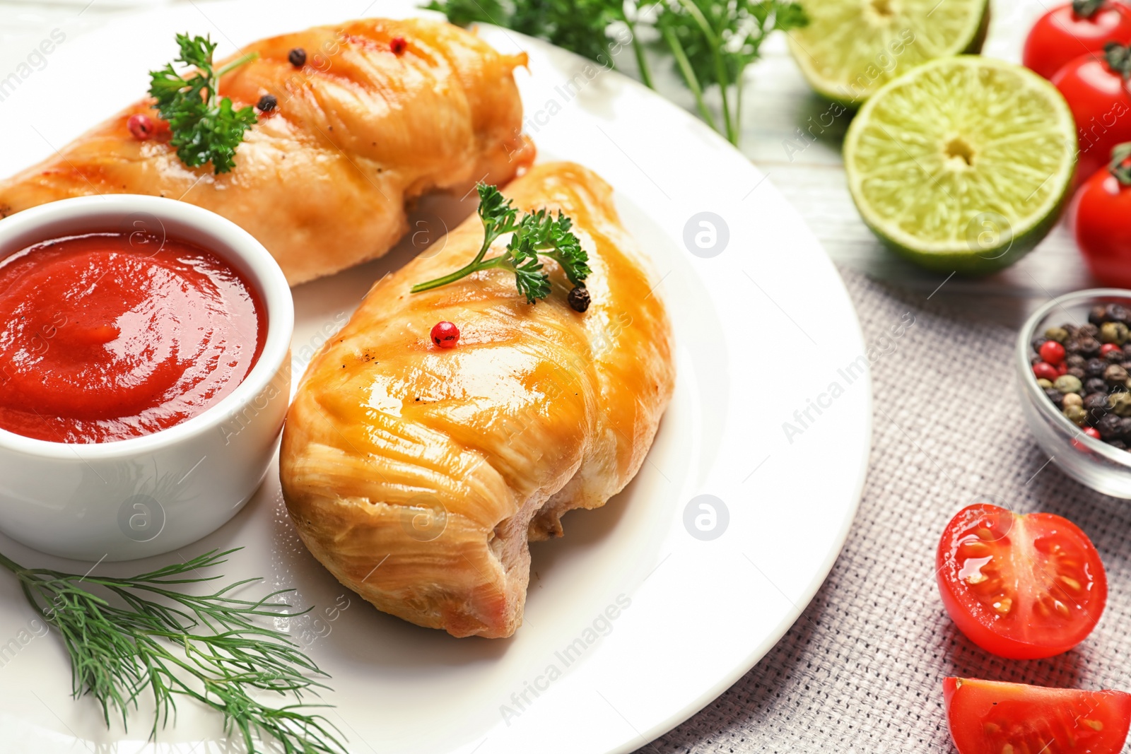 Photo of Plate with fried chicken breasts and sauce on table, closeup