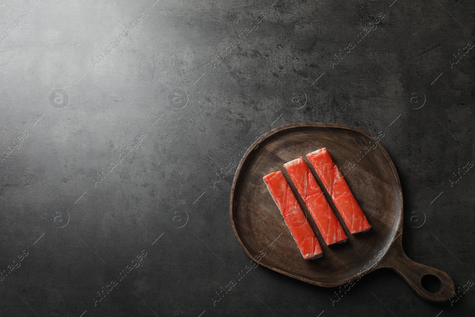 Photo of Crab sticks on grey table, top view. Space for text