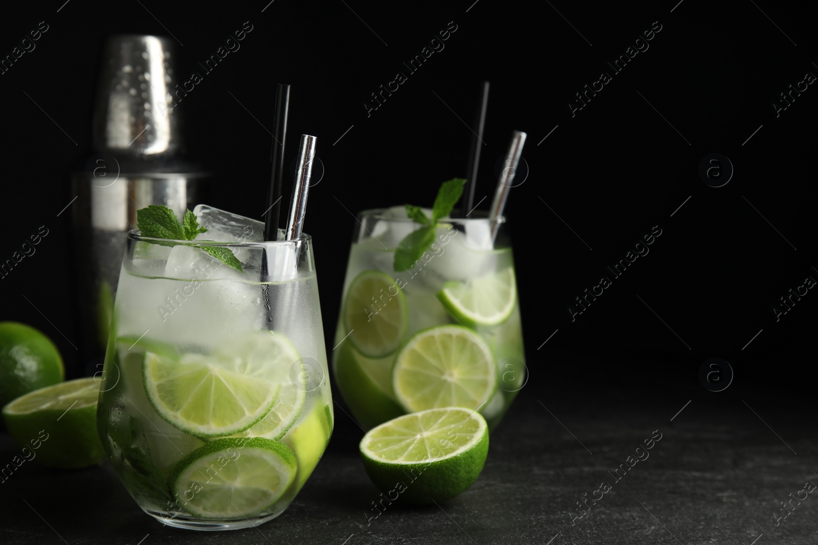 Photo of Delicious mojito and ingredients on black table