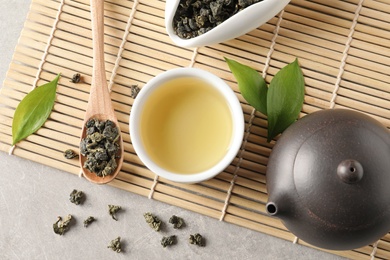 Photo of Flat lay composition with teapot and cup of Tie Guan Yin oolong on table