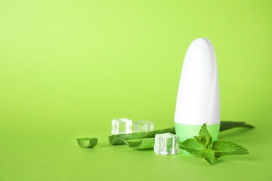 Photo of Roll-on deodorant, aloe, mint and ice on light green background, space for text