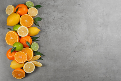 Flat lay composition with tangerines and different citrus fruits on grey background. Space for text