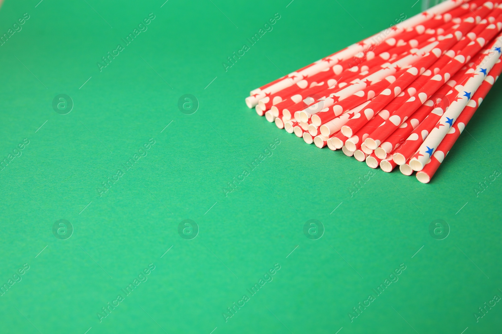 Photo of Many paper drinking straws on green background. Space for text