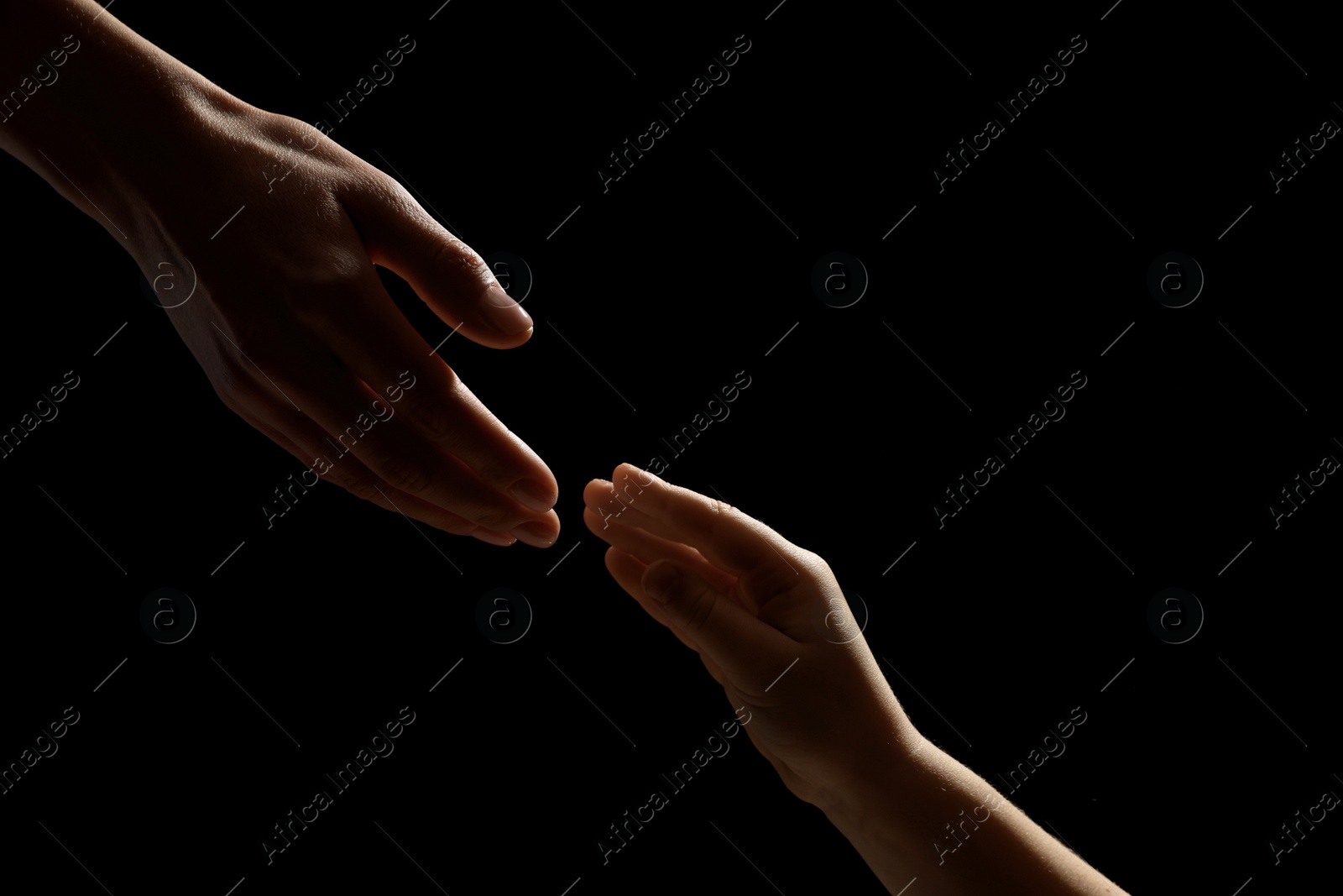 Photo of Woman with child on black background, closeup of hands