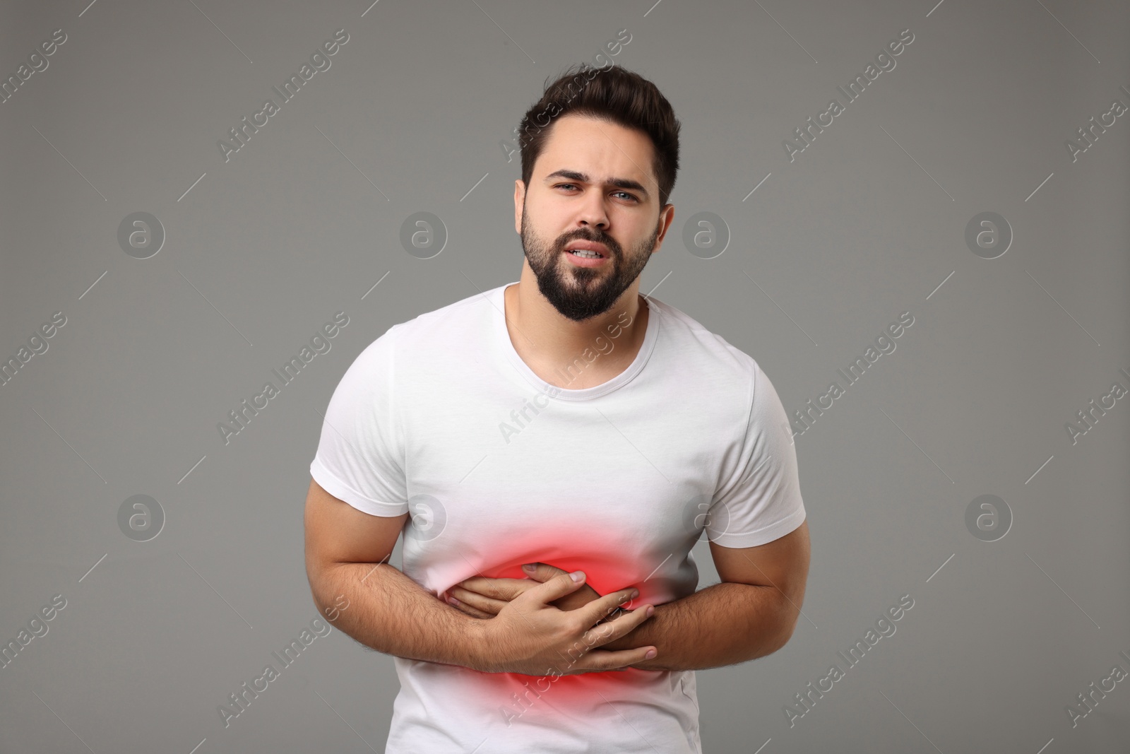 Image of Man suffering from stomach pain on grey background