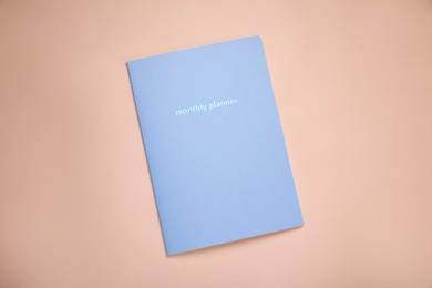 Photo of Monthly planner on beige background, top view