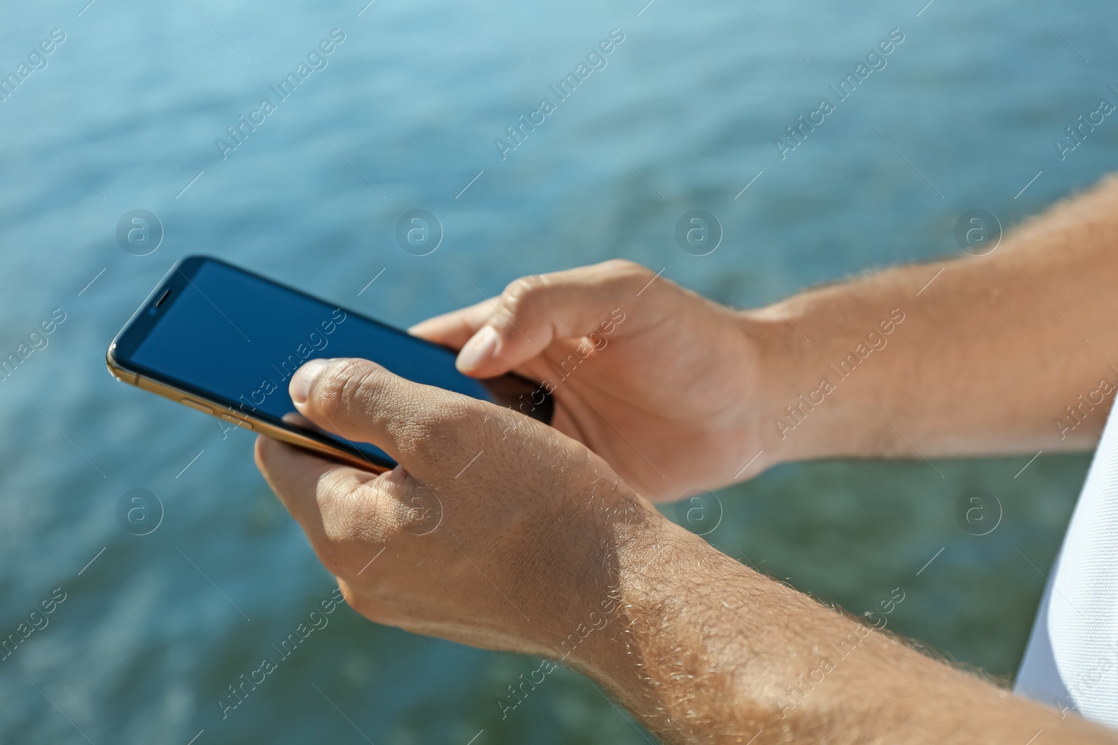 Photo of Man using modern mobile phone near river, closeup