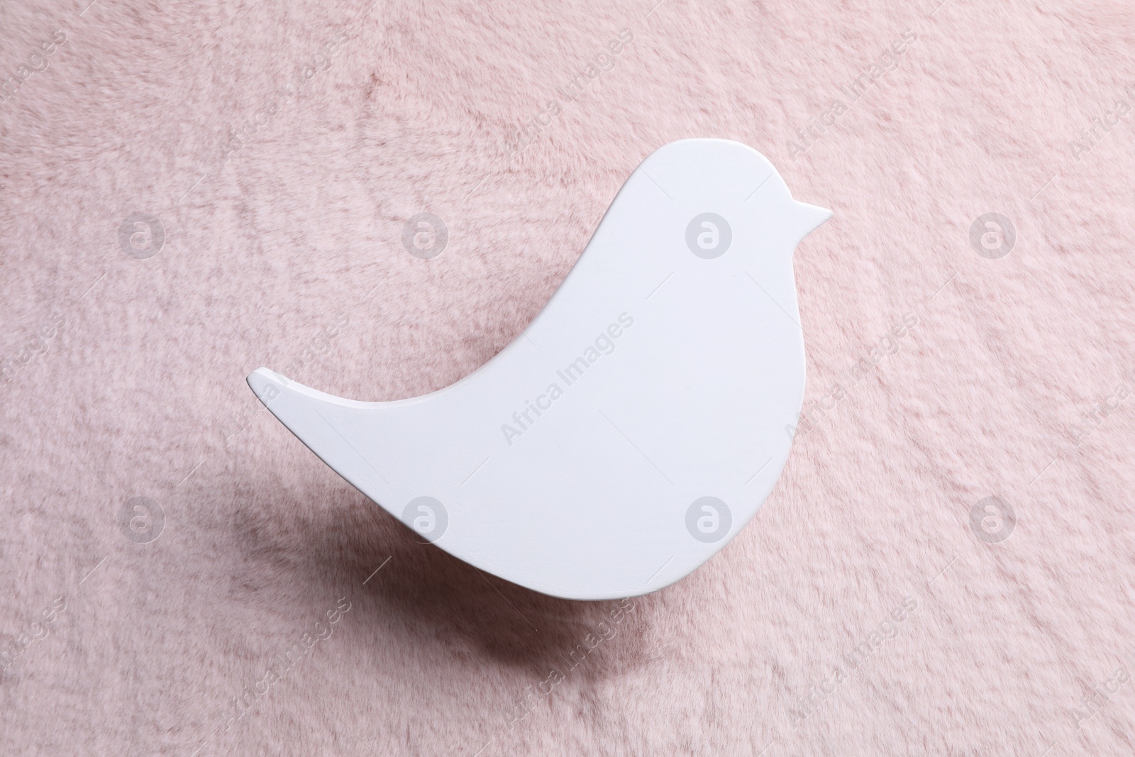 Photo of Bird shaped child's night lamp on pink fabric, top view