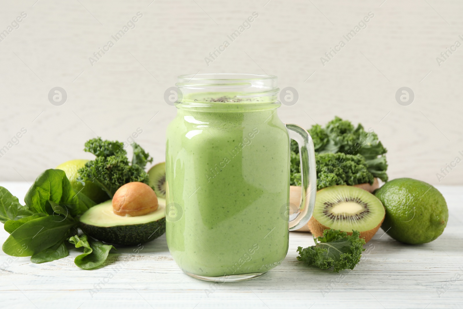 Photo of Tasty fresh kale smoothie on white wooden table