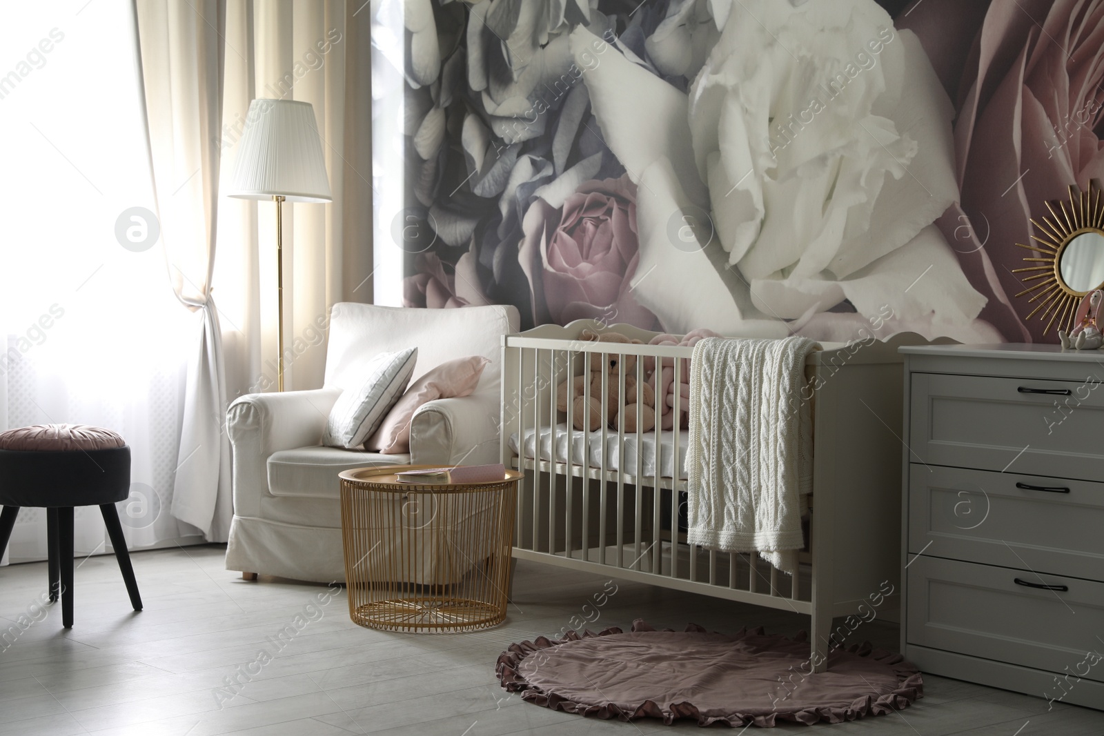 Photo of Baby room interior with stylish crib and floral wallpaper