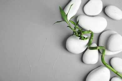 Photo of Zen stones and bamboo on grey background, top view with space for text