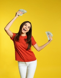 Young woman with money on color background