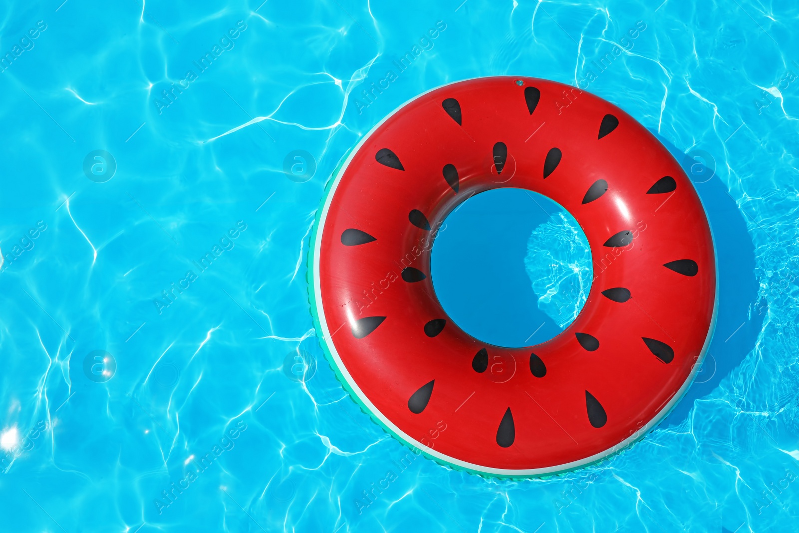 Photo of Inflatable ring floating in swimming pool on sunny day, top view with space for text