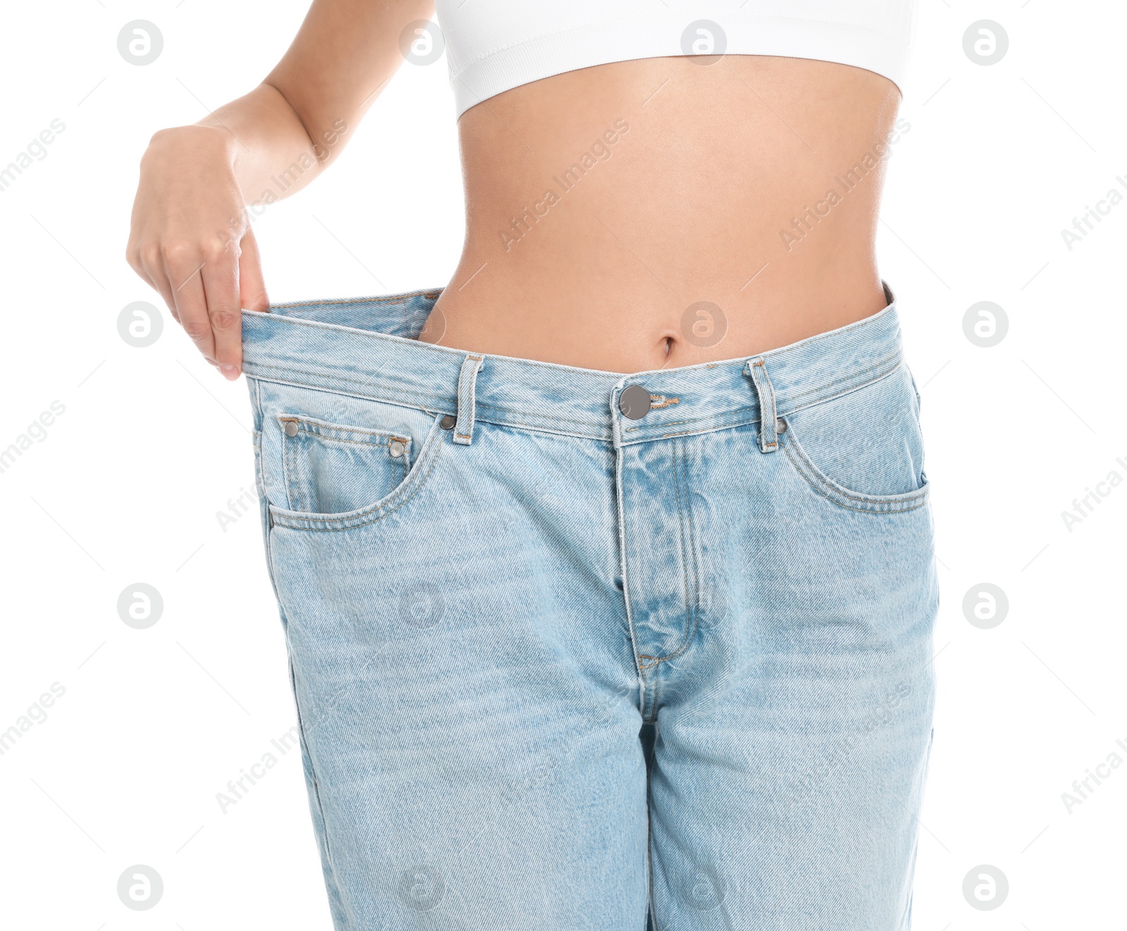 Photo of Slim young woman with smooth gentle skin in oversized jeans on white background, closeup. Beauty and body care concept