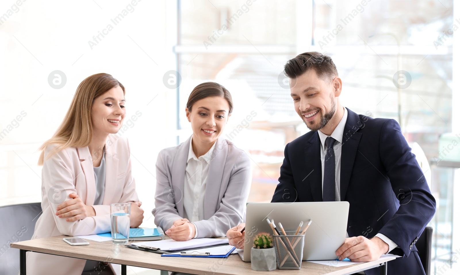 Photo of Young consultant working with clients in office