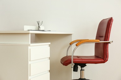 Photo of Stylish workplace interior with modern office chair and desk