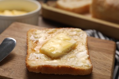 Photo of Melting butter, toast and knife on table, closeup