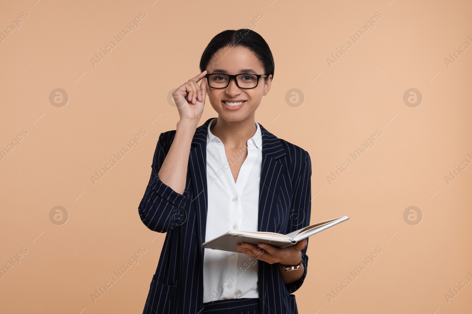 Photo of Beautiful secretary with notebook on beige background