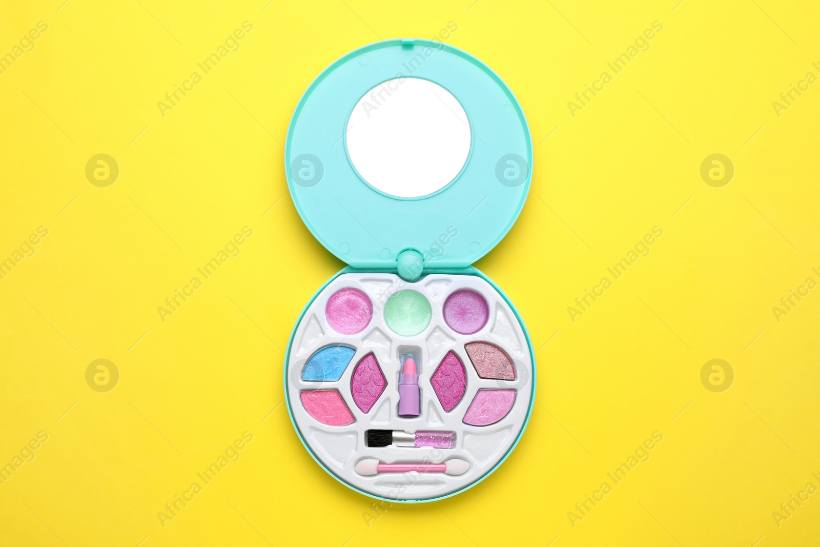 Photo of Decorative cosmetics for kids. Eye shadow palette with lipstick on yellow background, top view