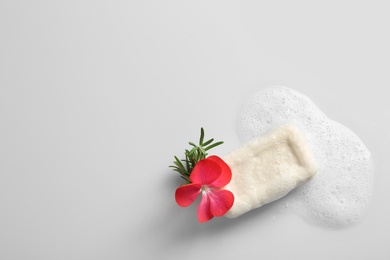 Soap bar, rosemary, flower and foam on white background, top view