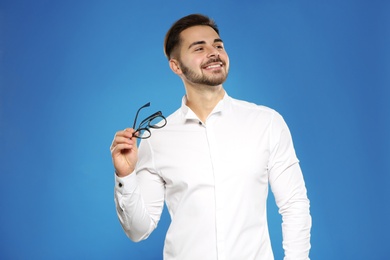 Portrait of handsome young man with glasses on color background