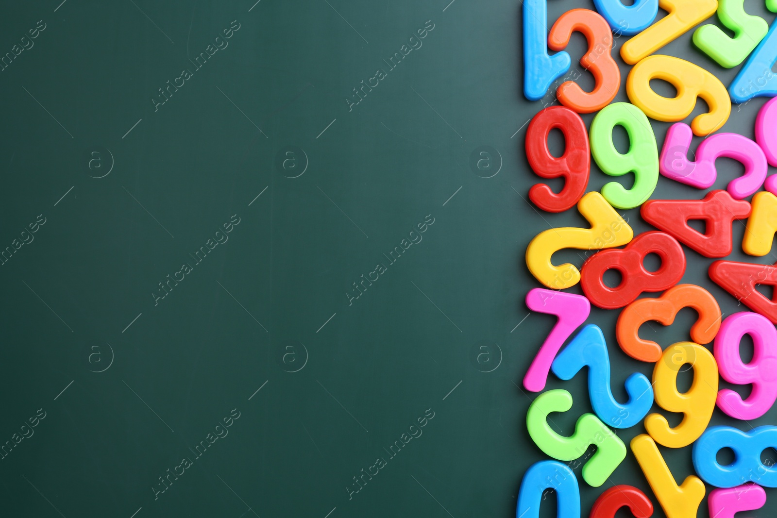 Photo of Colorful numbers on green background, flat lay. Space for text