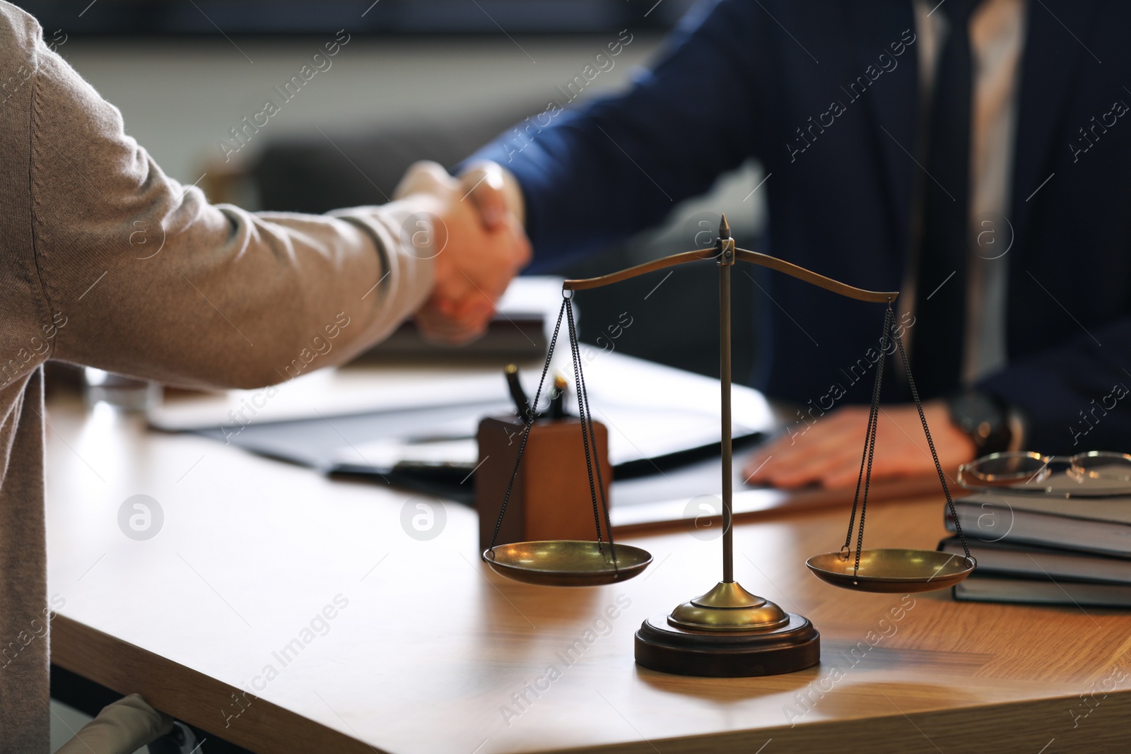 Photo of Male lawyer shaking hands with client in office, closeup