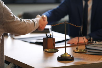 Male lawyer shaking hands with client in office, closeup