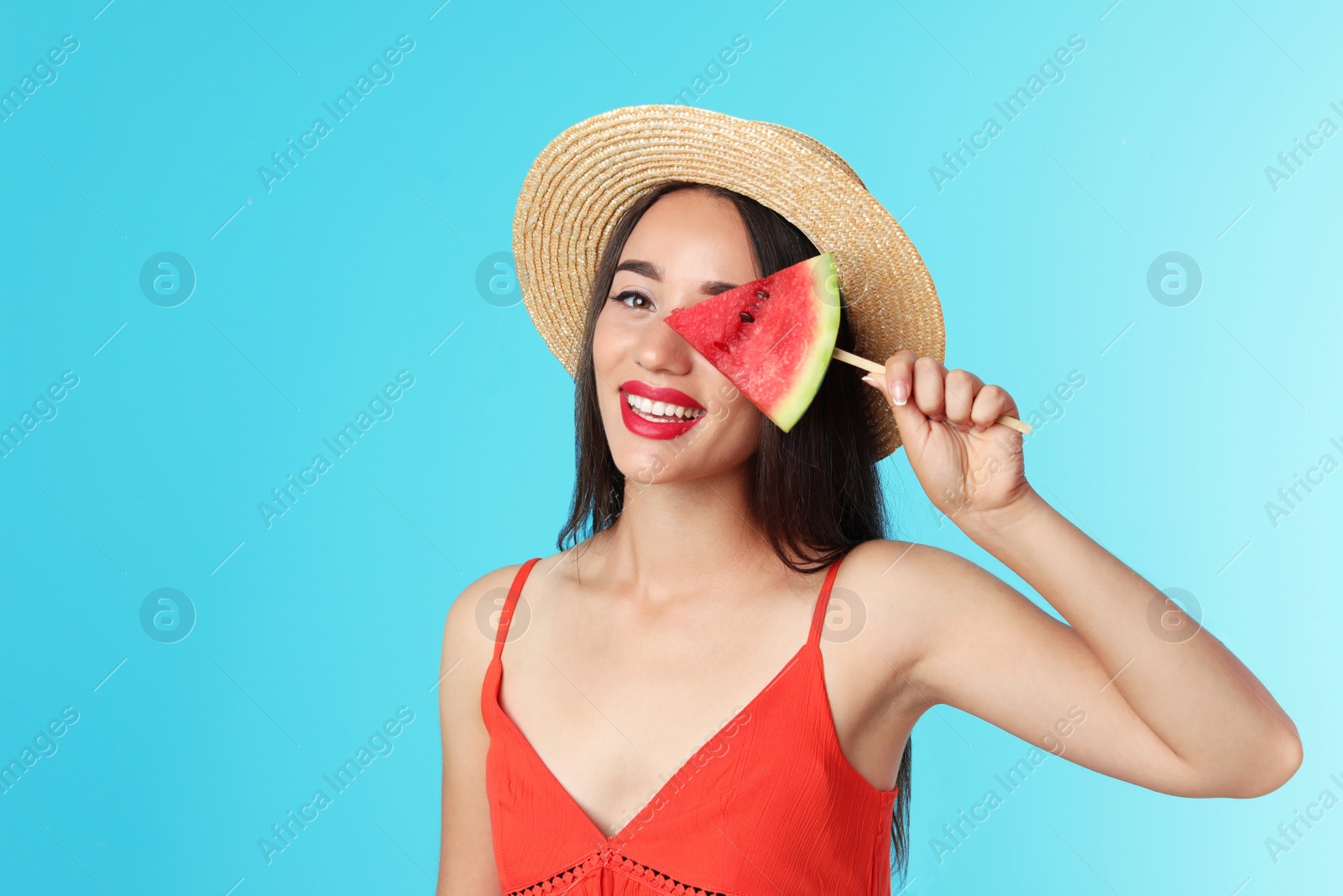 Photo of Beautiful young woman posing with watermelon on color background