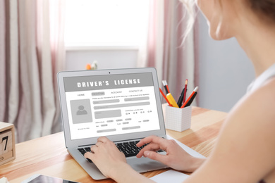 Image of Woman filling in driver's license form online on website using laptop, closeup