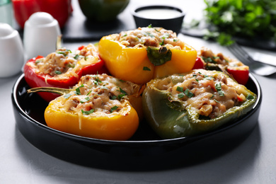 Photo of Tasty stuffed bell peppers served on grey table