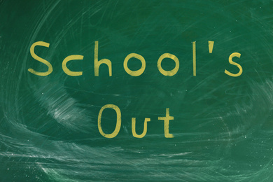 Text SCHOOL'S OUT written on green chalkboard