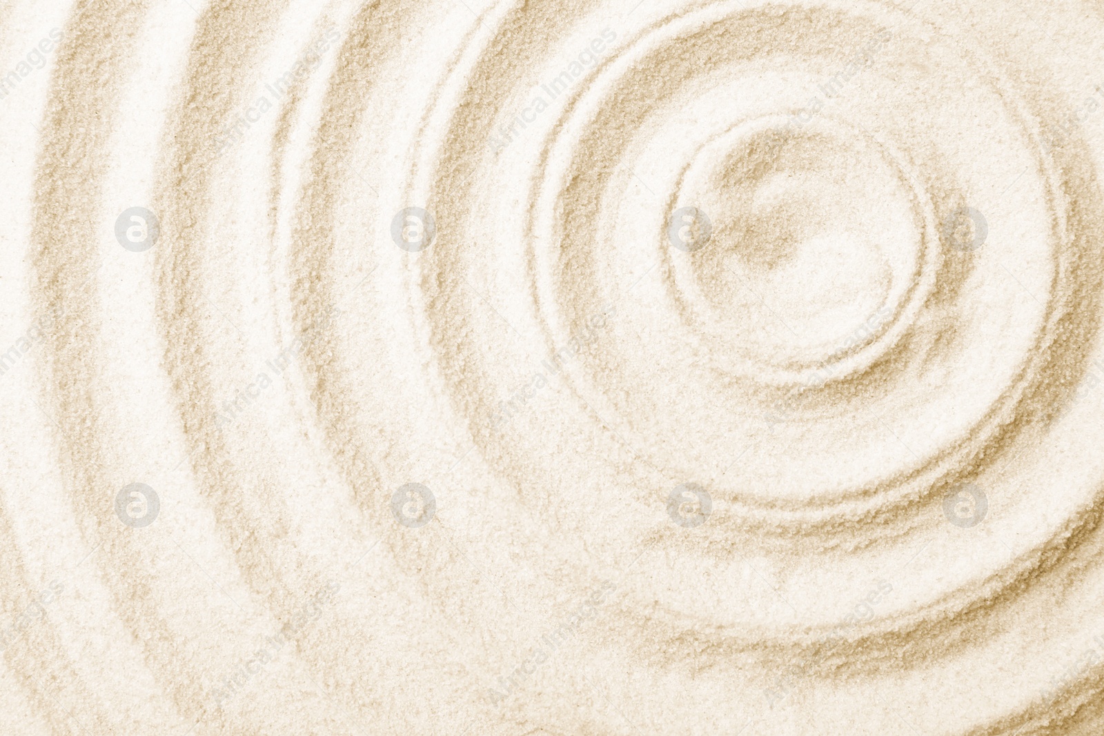 Photo of Zen garden pattern on sand as background, top view. Meditation and harmony