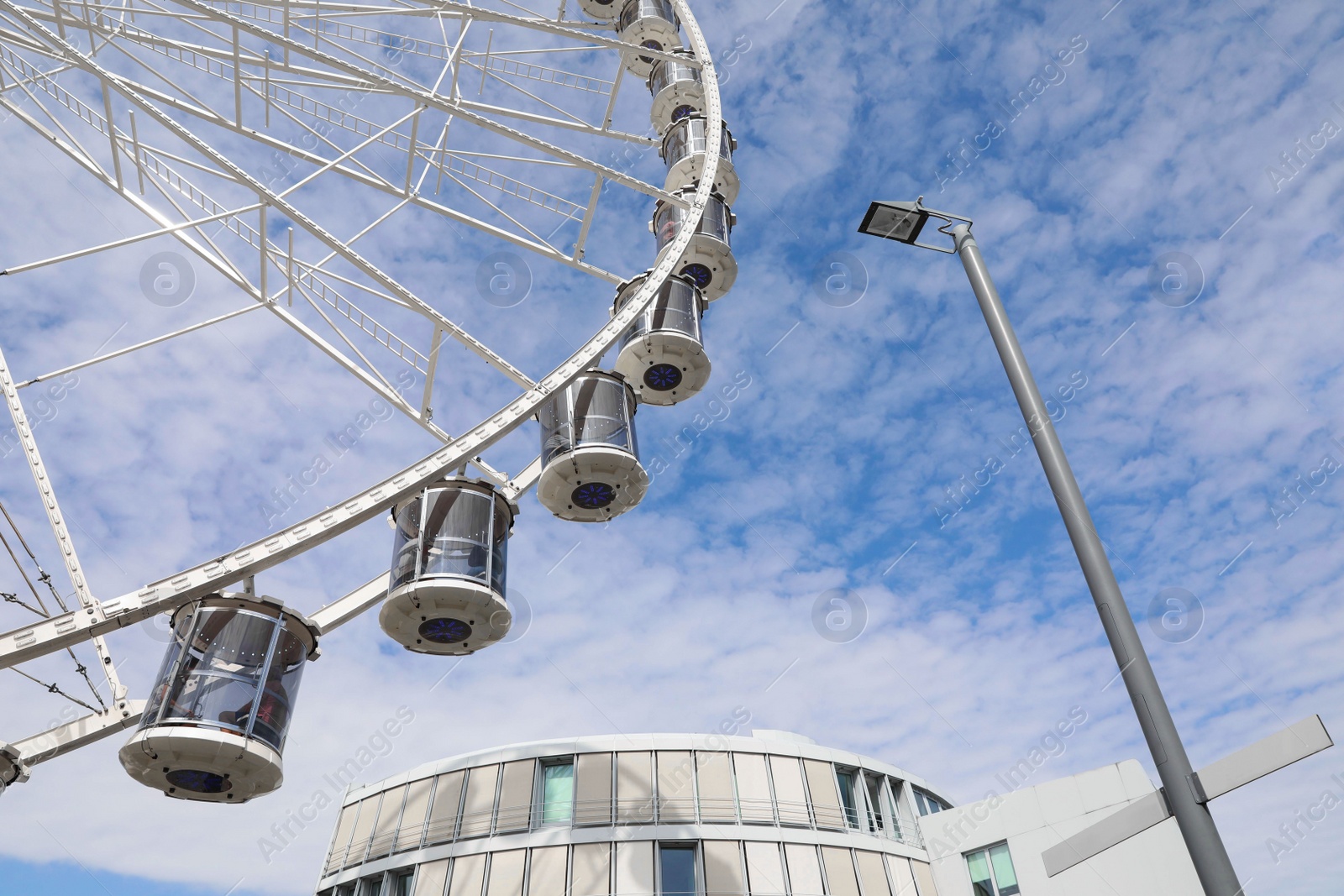 Photo of Beautiful Ferris wheel against cloudy sky, low angle view