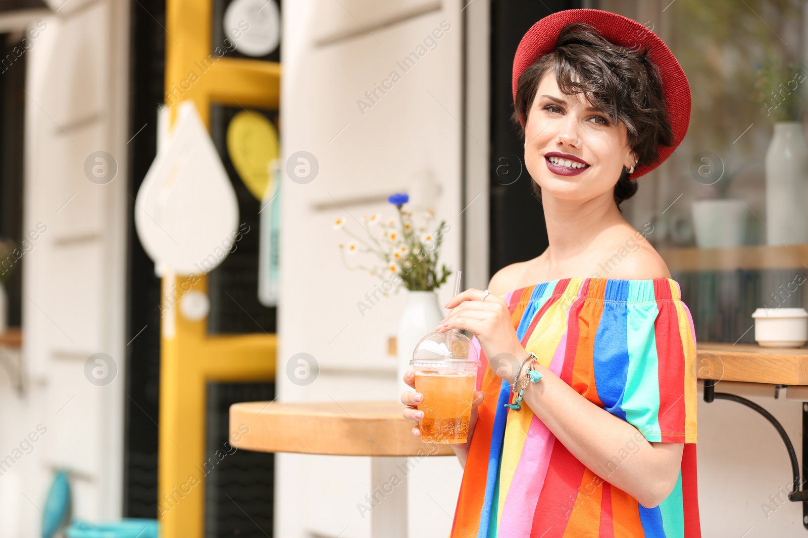 Photo of Young woman with cup of tasty lemonade outdoors