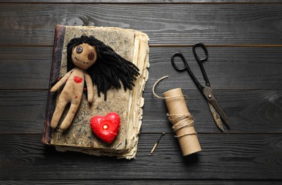Flat lay composition with voodoo doll on dark wooden table