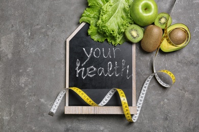 Flat lay composition with blackboard and fruits on gray background. Weight loss