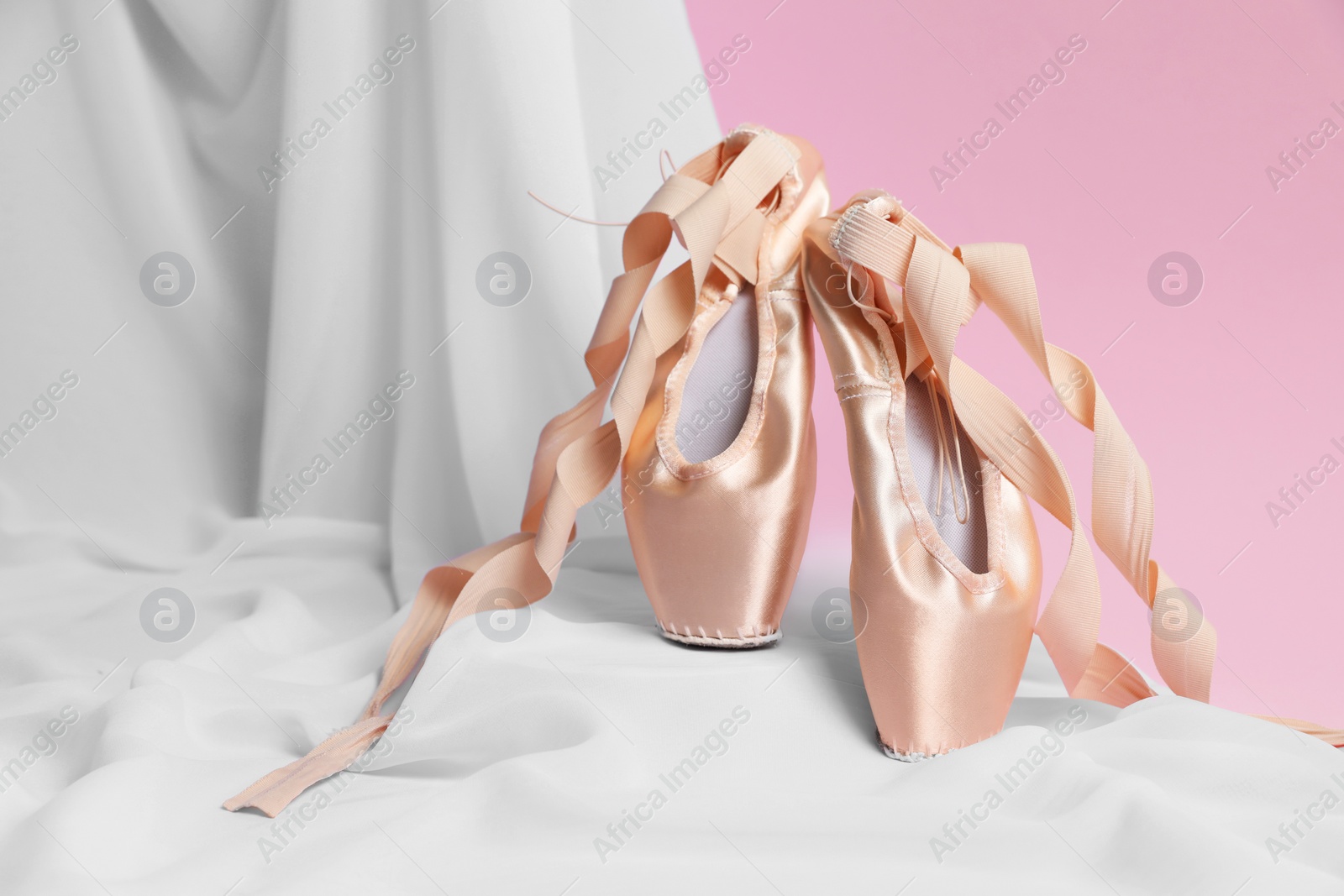 Photo of Ballet shoes. Stylish presentation of elegant pointes on pink background. Space for text