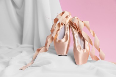 Photo of Ballet shoes. Stylish presentation of elegant pointes on pink background. Space for text