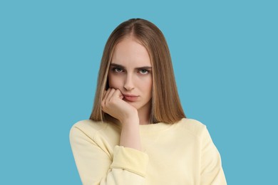 Photo of Portrait of resentful woman on light blue background
