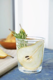 Photo of Refreshing pear cocktail with rosemary on table